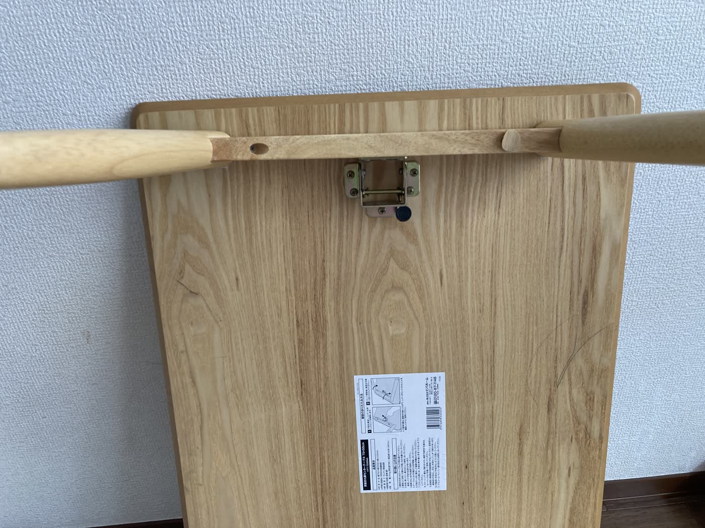 折りたたみ机の中央にある脚の開閉ボタンと連動部